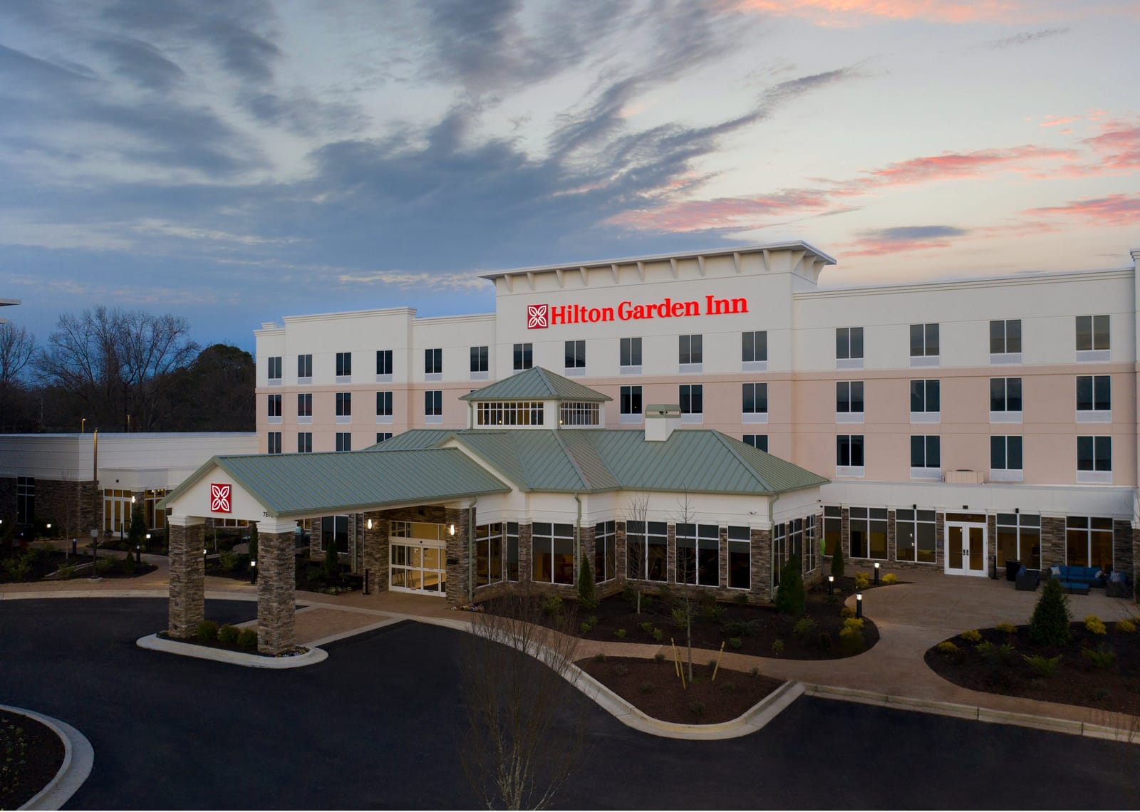 Hilton Garden Inn exterior at dusk with lit porte-cochère